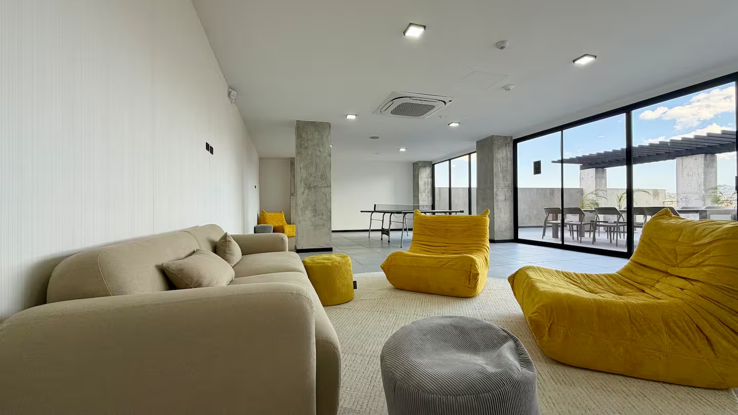 Indoor lounge with yellow bean bags, sofa, and city views at Art Haus Tower