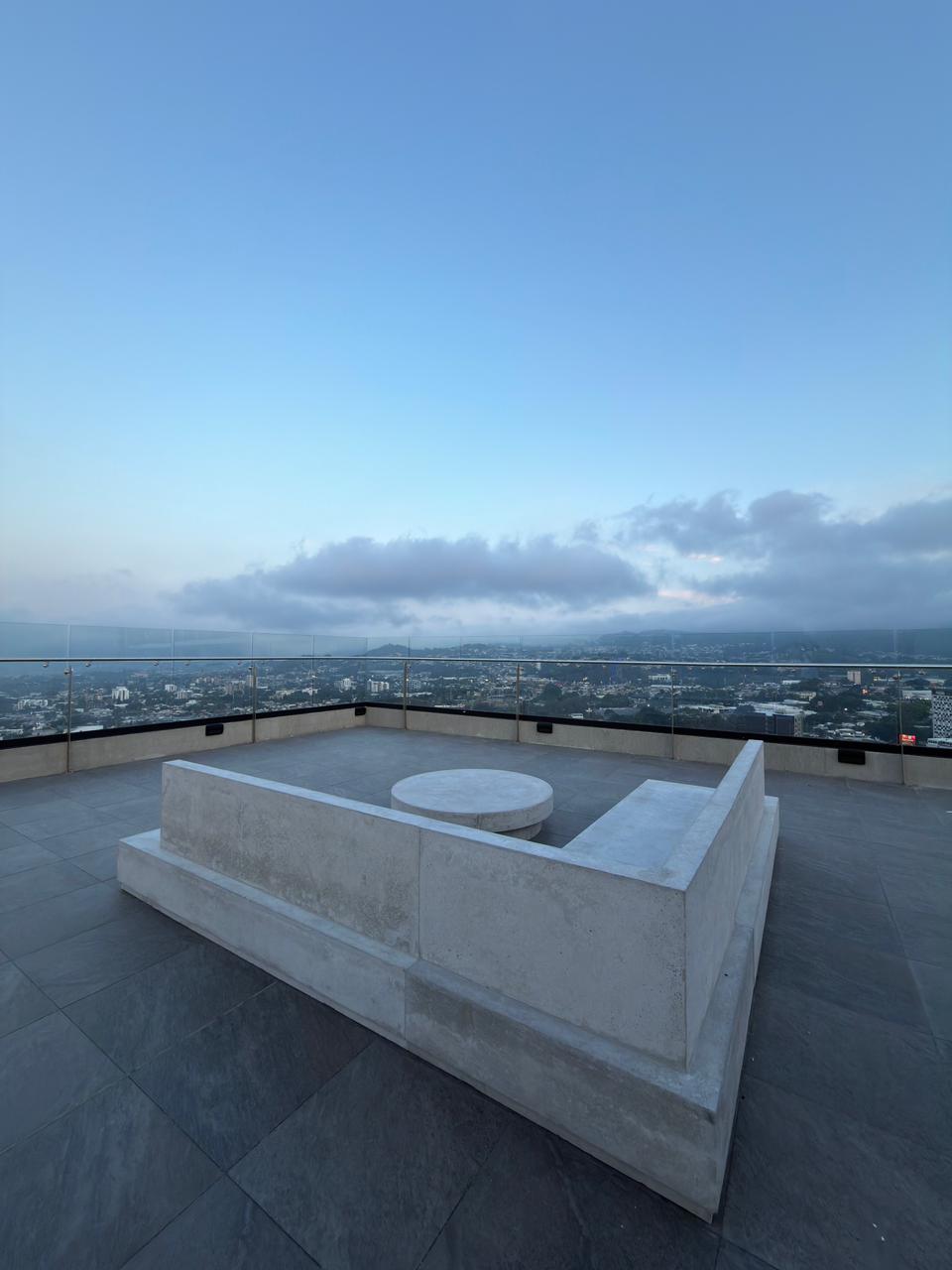 Rooftop terrace with concrete seating and panoramic city views at Art Haus Tower