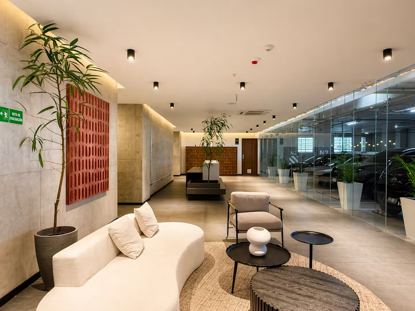 Modern lobby interior with seating, plants, and glass parking wall at Art Haus Tower